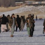Taliban fighters walk at the frozen Qargha Lake, near Kabul, Afghanistan. Photograph: Hussein Malla/AP