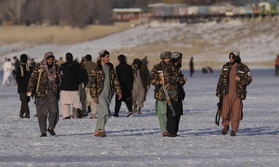 Taliban fighters walk at the frozen Qargha Lake, near Kabul, Afghanistan. Photograph: Hussein Malla/AP