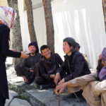 An Afghan woman journalist conducts an interview with bystanders.