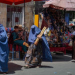 Burqa-clad women shop at a market in Kabul following the Taliban’s military takeover of Afghanistan on Aug. 23. HOSHANG HASHIMI/AFP VIA GETTY IMAGES