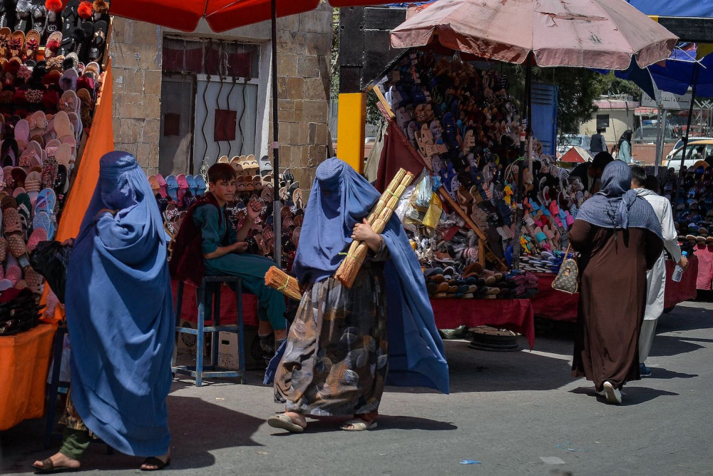 Burqa-clad women shop at a market in Kabul following the Taliban’s military takeover of Afghanistan on Aug. 23. HOSHANG HASHIMI/AFP VIA GETTY IMAGES