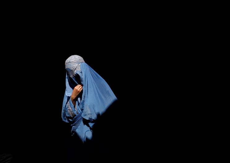 A burqa-clad Afghan woman walks in an old bazaar in Kabul. REUTERS/Ahmad Masood (AFGHANISTAN)