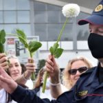 Women pf Belarus protesters offer flowers to police officers during a demonstration. Photograph: Sergei Gapon/AFP/Getty Images
