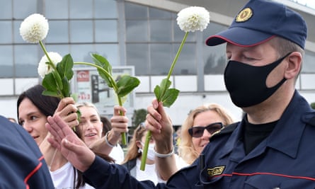 Women pf Belarus protesters offer flowers to police officers during a demonstration. Photograph: Sergei Gapon/AFP/Getty Images