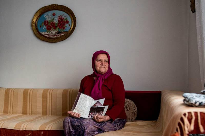 Dzejma Pasic holds a letter and photos of her children; her two sons were killed in what was ruled by a UN international court to have been genocide.