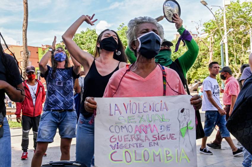 Women protest against violence against women with a sign reading 'Sexual violence as a war weapon still exists in Colombia' in Medellin, Colombia, on June 19, 2020, amid the new coronavirus pandemic [Photo by Joaquin Sarmiento/AFP]