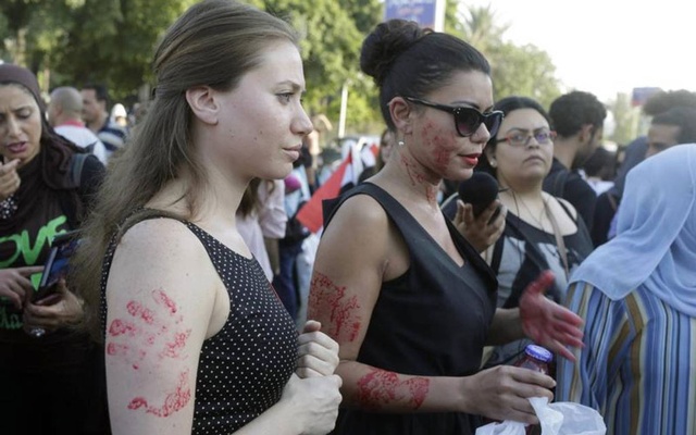 Women, with red paint on their bodies to symbolise blood, protest against sexual harassment in front of the opera house in Cairo June 14, 2014, after a woman was sexually assaulted by a mob. REUTERS