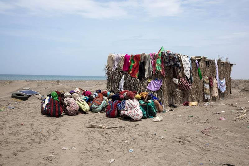Dozens of Ethiopian women sat inside a compound, known as “hosh” in Arabic, as they wait for the next leg of their journey to Saudi Arabia in Ras al-Ara.