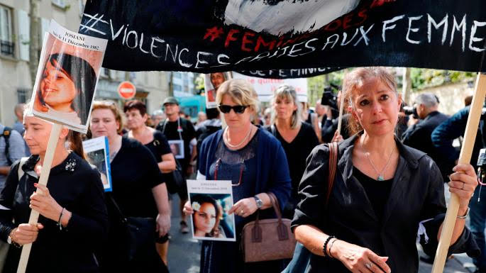 Women hold pictures of victims and placards denouncing the violence against women in a protest march in Paris. THOMAS SAMSON/GETTY IMAGES