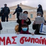 The women stood at the stairs of Syntagma Square opposite the Parliament, wearing masks and maintaining their social distance.