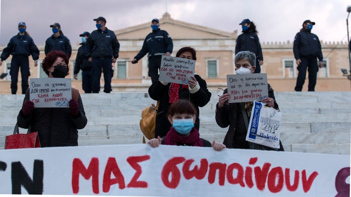 The women stood at the stairs of Syntagma Square opposite the Parliament, wearing masks and maintaining their social distance.