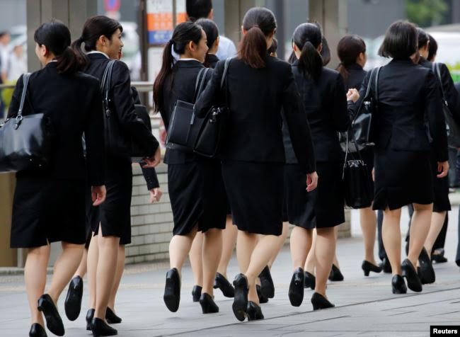 Female office workers wearing high heels, clothes and bags of the same color make their way at a business district in Tokyo, Japan, June 4, 2019. (REUTERS/Kim Kyung-Hoon)