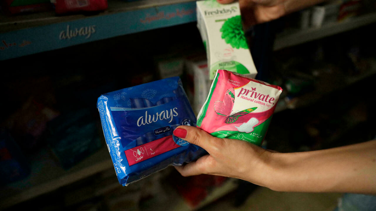 A Lebanese woman inspects prices of female sanitary pads at a shop in the capital Beirut on June 23, 2021. © Jospeh Eid, AFP