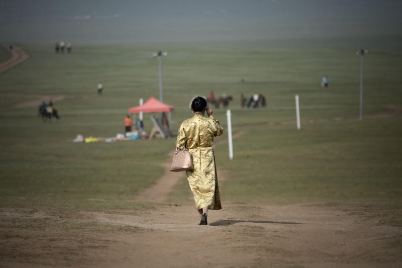 A Mongolian woman walks along a road on the outskirts of Ulaanbaatar. WANG ZHAO/GETTY IMAGES