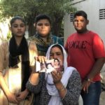 Rita Raja, pictured here with her children, holds up photos of her 13-year-old who had allegedly been abducted and forced to covert her religion and marry her 44-year-old Muslim neighbour. Credit: Zofeen T. Ebrahim/IPS