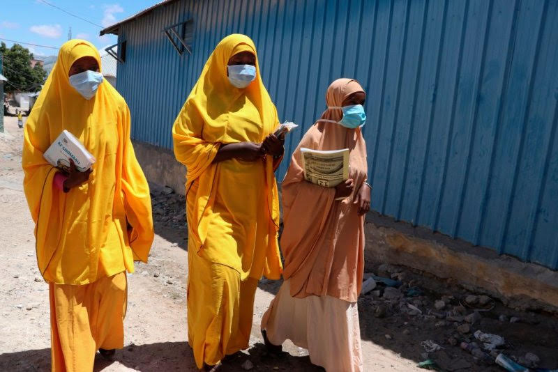 Students wearing face masks walk in a Mogadishu neighborhood on March 19, 2020 in Somalia. ABDIRAZAK HUSSEIN FARAH—AFP/Getty Images