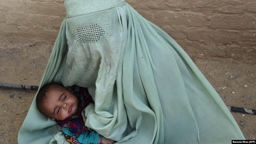 An Afghan refugee woman holds her baby at a United Nations repatriation center on the outskirts of Quetta, Pakistan.