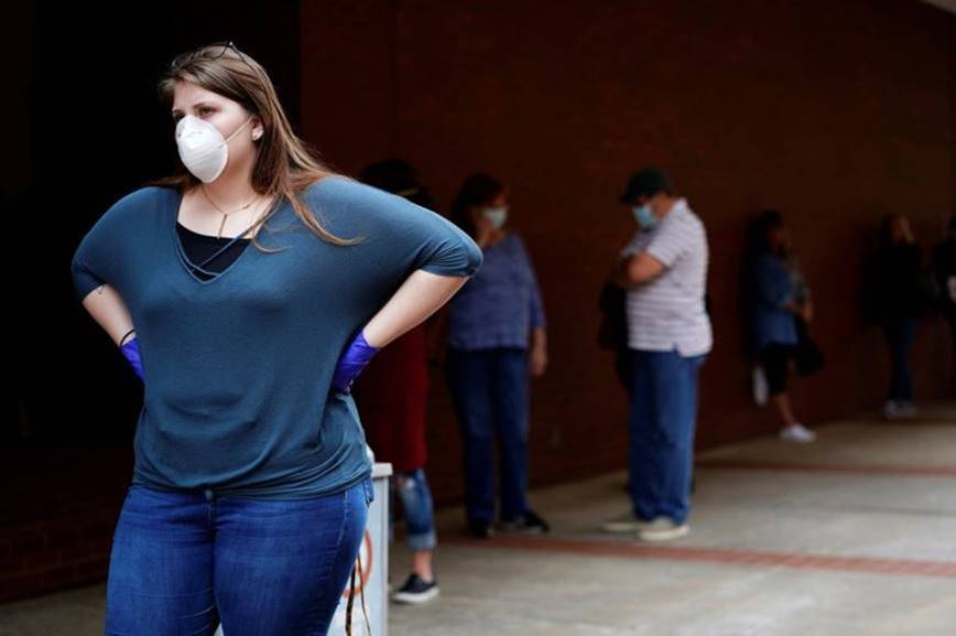 A woman who lost her job waits in line to file for unemployment following an outbreak of the coronavirus, at an Arkansas Workforce Center in Fort Smith, Ark., April 6, 2020. --Nick Oxford—REUTERS