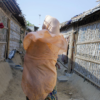 ©Farzana Hossen/British Red Cross - A woman walking through the widow's block.