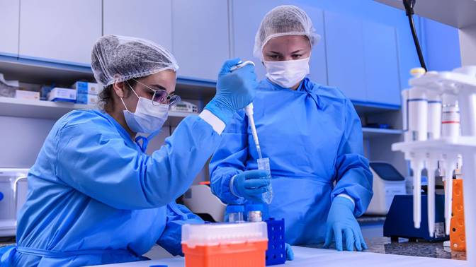 Biomedic Andressa Parreiras and biologist Larissa Vuitika extract genetic material from the SARS-CoV-2 virus on March 24, 2020 in Belo Horizonte, Brazil. Visual: Pedro Vilela / Getty Images
